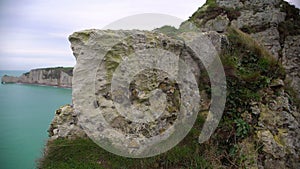 White chalk cliff covered with grass, view on rocks and sea from mountain top