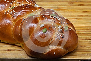 A white challah bun on a wooden board