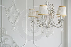 White chandelier in the interior of the bedroom photo