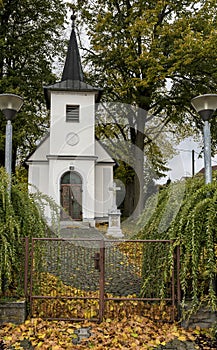 White chapel among deciduous trees with colored leaves