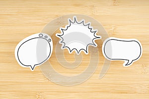 White chat bubbles on wooden background