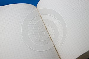 White checkered page of an open notebook fills the image plane