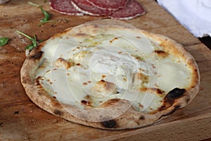 White cheese pizza rest on a wooden table with copy space for your text