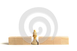 White chess bishop next to wooden blocks