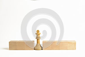 White chess king next to wooden blocks