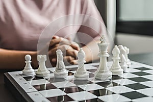 White chess pictures laid out on a chessboard, concept comparing playing chessboard to business administration.