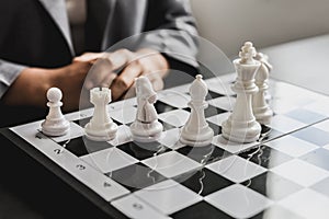 White chess pictures laid out on a chessboard, concept comparing playing chessboard to business administration.