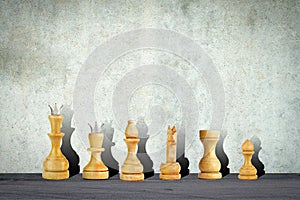 White chess pieces on the background of a concrete wall. Copy space. Strategy. Sport