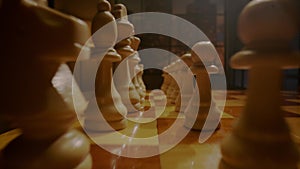 White chess pieces stand on wooden chessboard before game