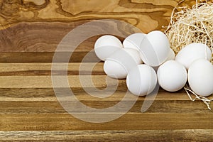 White chicken eggs and broken eggs on wooden board or table.
