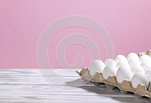 White Chicken eggs in a cardboard box on a pink background, Raw Fresh Chicken Eggs in a paper container, Natural Eko
