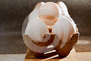 White chicken eggs in cardboard on wooden surface with interesting light. The concept of taking pictures of food. Fresh eggs from