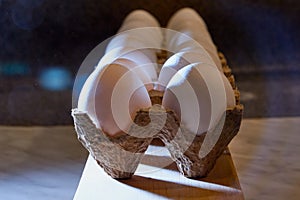 White chicken eggs in cardboard on wooden surface with interesting light. The concept of taking pictures of food. Fresh eggs from