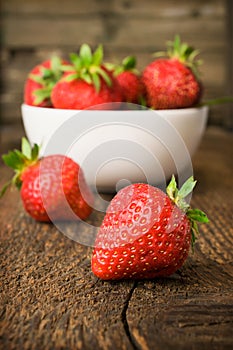 White china bowl filled with succulent fresh ripe red strawberries