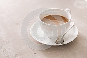 White china cup of tea with milk on a plain background