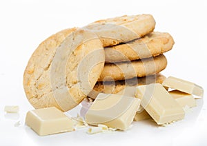 White chocolate biscuit cookies with chocolate blocks and curls on white background