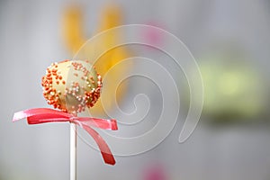 White chocolate cake pop decorated with colorfull confectionery sprinkles on a pastel background. Party concept