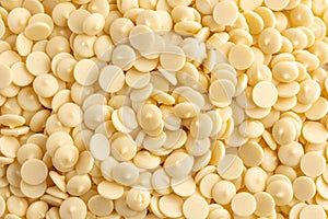 White chocolate chips or granules background, top view.