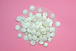 White chocolate drops on a pink background