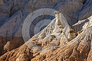 White and Chocolate Hoodoos Against Blue Cliffs