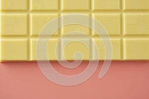 White chocolate isolated over pink background. Copy space