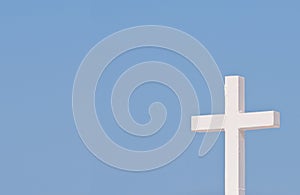 White Christian cross on blue sky