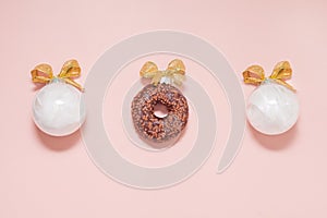 white christmas balls wiht donut and golden bows. new year creative decoration on pink background
