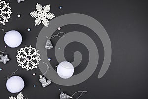 White Christmas decorations lie on a black background. Copy space. Christmas card mockup