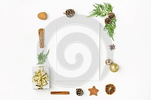 White Christmas frame mockup. Gift box in wrapped silver paper with golden ribbon pine cones juniper nuts cinnamon. New Year