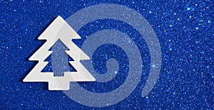 White christmas tree on gllitter blue background.Happy new year,Merry Christmas or winter holidays concept for design.