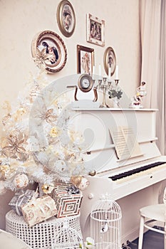 White Christmas tree with hand made ornaments and white piano. Winter time. New Year holiday.