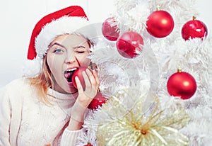 White christmas tree red balls. Beautiful Woman in Santa Hat at Home. We wish you a merry christmas tree, elegant party