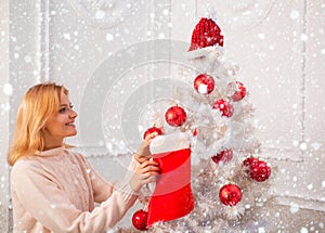 Girl in snow. White christmas tree red balls. Christmas stockings. Home Christmas atmosphere. Winter holidays and people