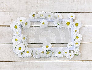 White chrysanthemum and frame on white wooden table