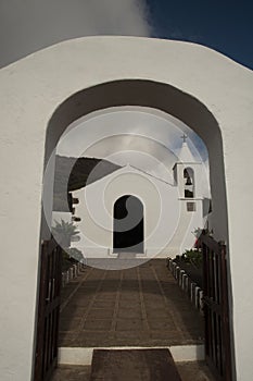 White church with an arch under a cloudy sky in Sabinosa in Spain photo