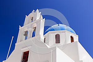 A white church with blue dome in Oia or Ia on Santorini island, Greece.