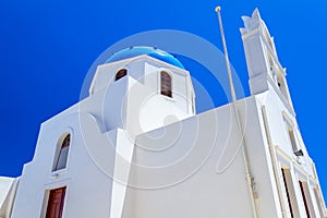 White church with blue dome in Oia town on Santorini island, Greece