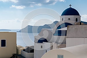 White church with blue dome in Oia village, Santorini, Greece.