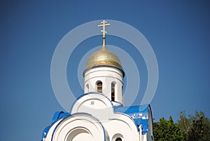 White church with a golden dome on a blue sky background