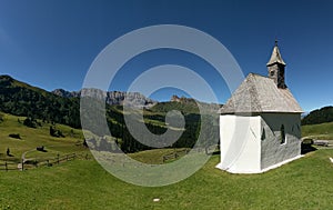 White church in hillside, Alpi di Siusi, Dolomites, Italy photo