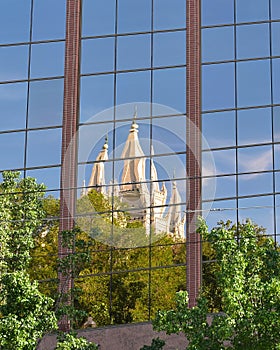 White church towers mirrored on the facade of a modern glass building