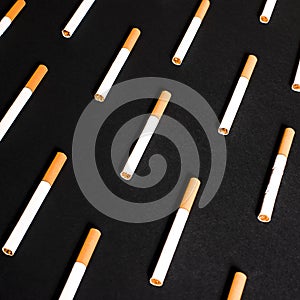 White cigarettes with orange filter lined in a row in order