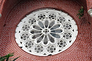 White Circle Mortar flower pattern with Stained Glass and red brick of exterior of church gable at cathedral of the holy trinity.