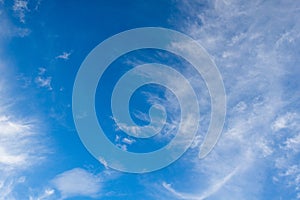 White cirrus clouds in the blue sky on a clear day in the summer. Used as a background image
