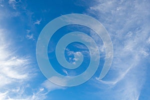 White cirrus clouds in the blue sky on a clear day in the summer. Used as a background image