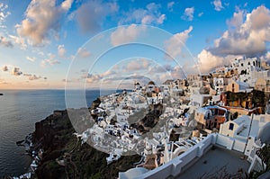 White city on a slope of a hill at sunset, Oia, Santorini, Greece
