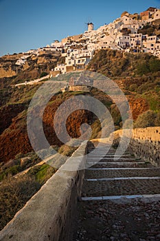 White city on a slope of a hill at sunset, Oia, Santorini, Greece