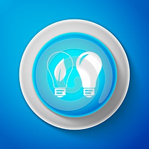 White Classic Lamp and Light bulb with leaf inside icon isolated on blue background. Lighting electric lamp. Green eco