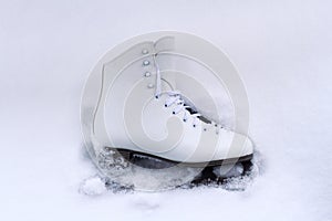 White classical iceskate shoe partially covered in snow