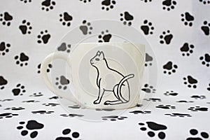 White clay mug with the Egyptian hieroglyph Cat. Handmade. Decor engobe, covered with transparent glaze, two firing